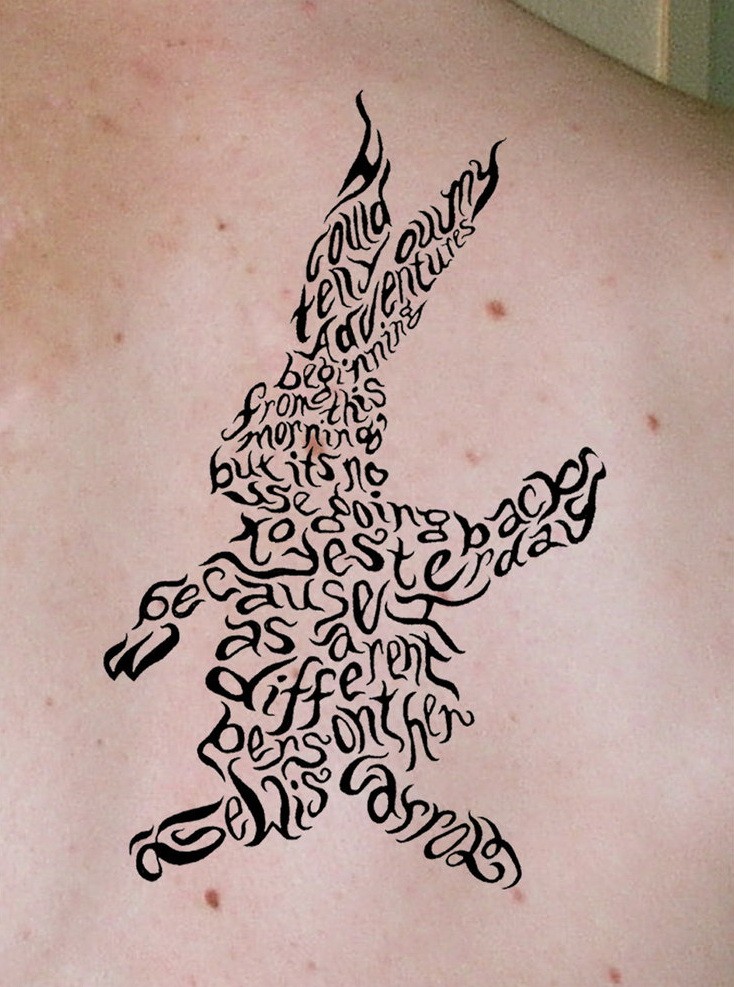 Black-ink lettered hare tattoo on back