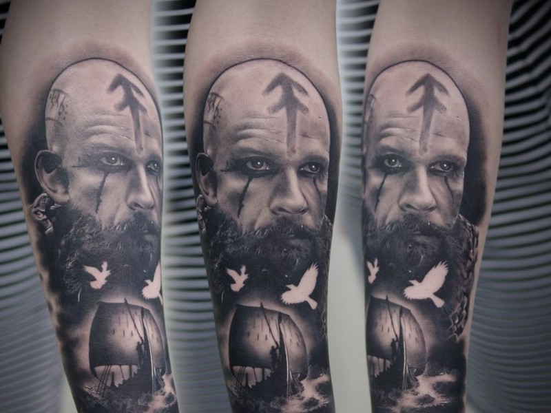 Black grey portrait of viking with ship tattoo