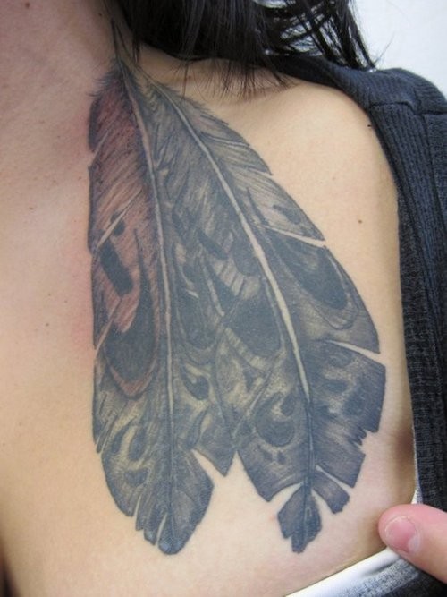 Black spotted eagle feather tattoo on chest