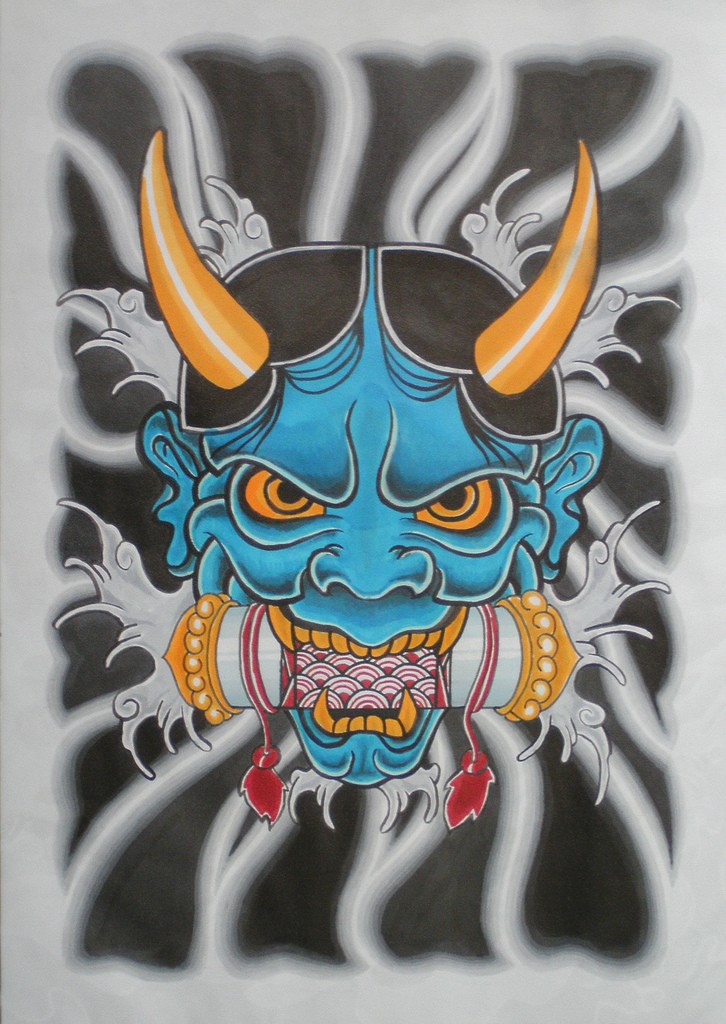 Blue japanese devil with orangre eyes and scroll in teeth tattoo design