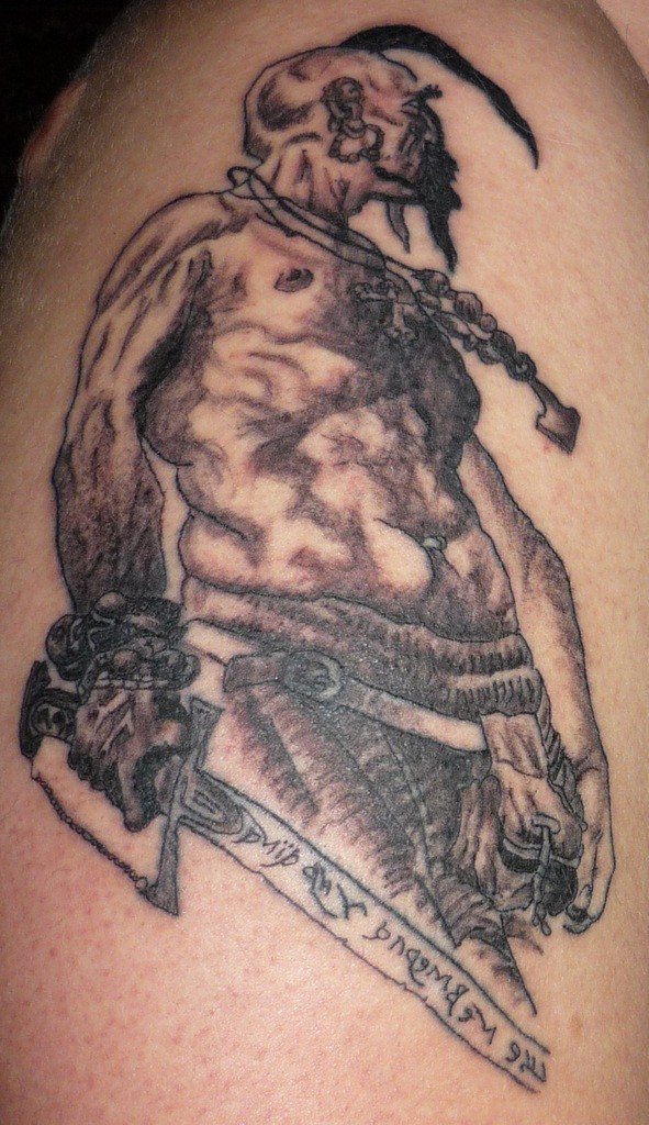 Brave Cossack with graven sword tattoo on shoulder