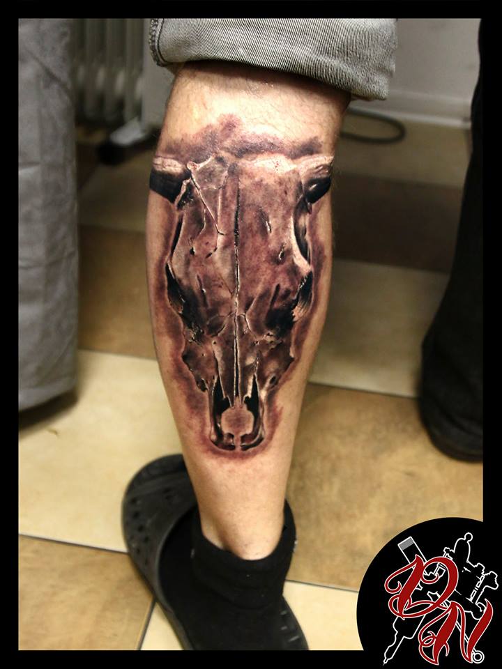 Tatuaje de cráneo de toro en la pierna