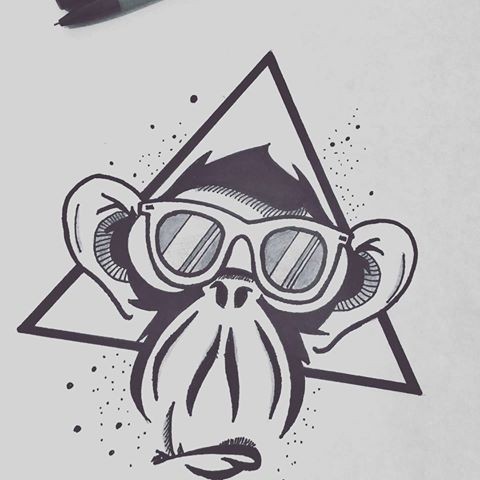 Cartoon chimpanzee muzzle in sun glasses in triangle frame tattoo design