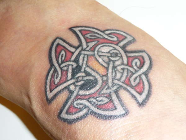 Tatuaje en el brazo, cruz celta con yin yang