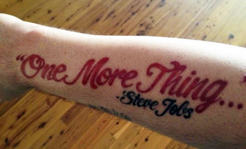 Schick Tattoo mit rot geschriebenem Spruch von Steve Jobs  " Noch ein Ding..." am Arm