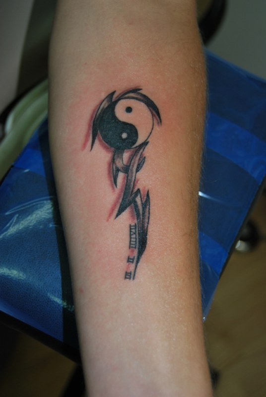 Tatuaje en el brazo, yin yang de tamaño medio