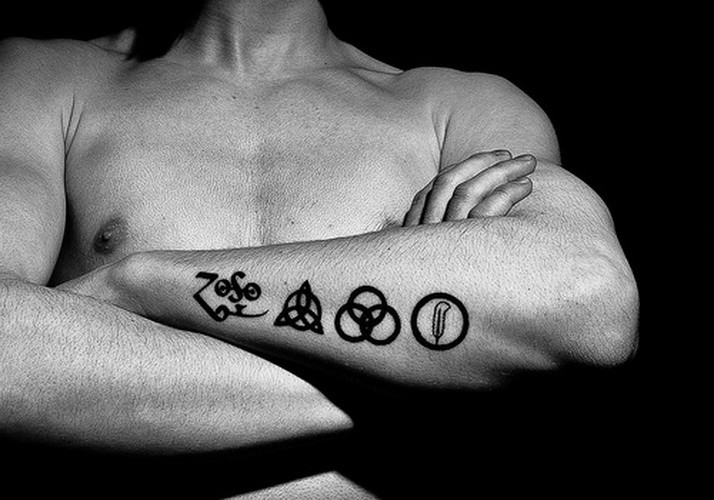 Tatuaje en el antebrazo, cuatro signos, tinta negra