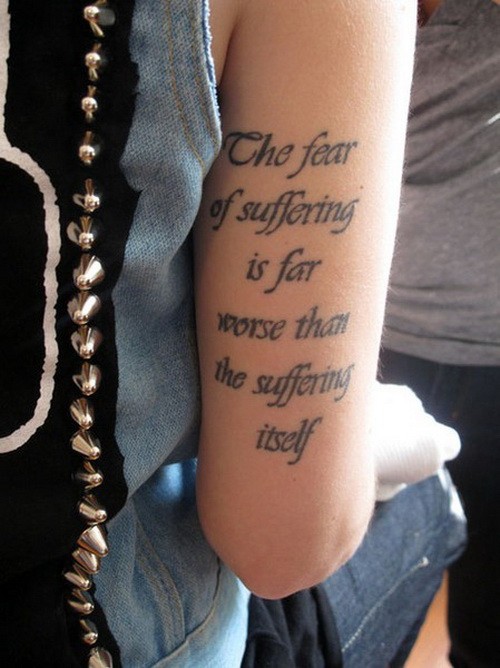 Tatuaje en el brazo,  cita filosófica con letra cursiva negra