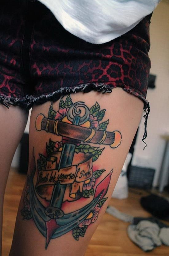 Colored anchor with flowers and lettering tattoo on thigh