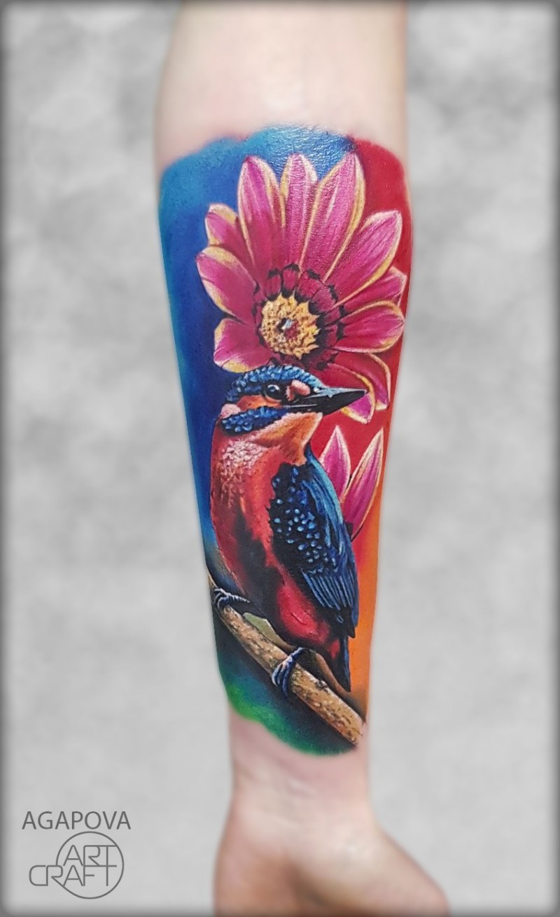 Tatuagem feminina colorida com pássaro e flor