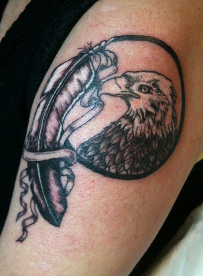 Cool black-and-white eagle portrait and ribboned feather tattoo on arm