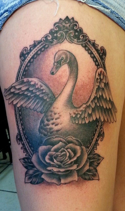 Cool black-and-white swan in mirror frame with rose tattoo on thigh