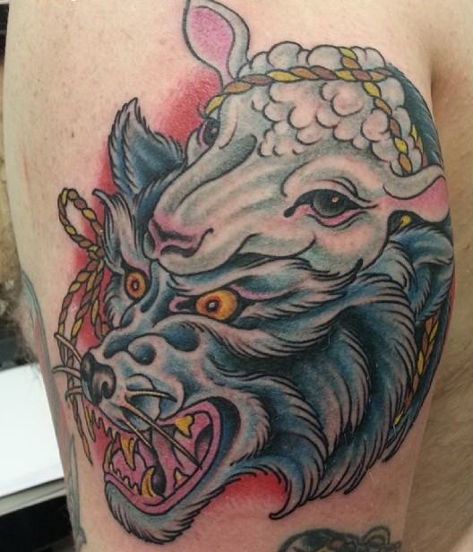 Cool colorful wolf in sheep skin tattoo on upper arm