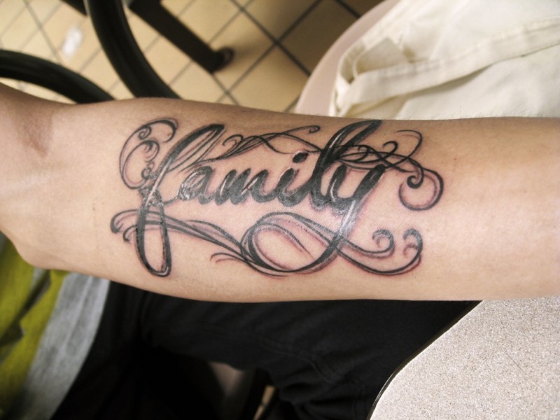Tatuaje en el antebrazo, palabra familia grande negra