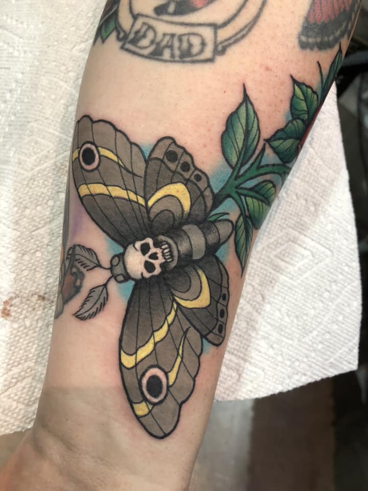 Cool moth with skull tattoo on forearm