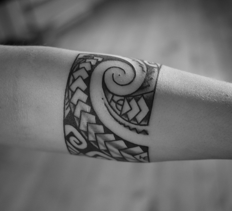 Cool ornated black-and-white band tattoo on forearm