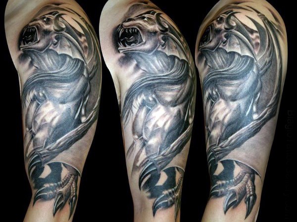 Creepy looking detailed upper arm tattoo of demonic gargoyle