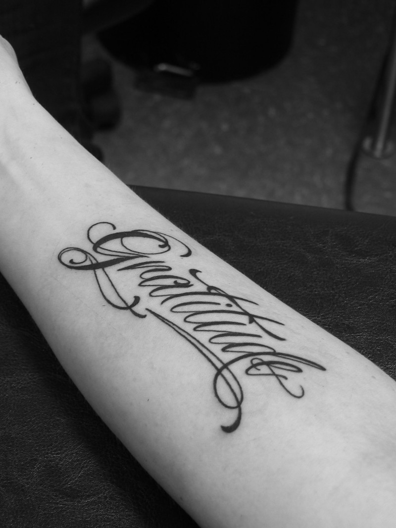 Tatuaje en el antebrazo,  inscripción, letra cursiva elegante