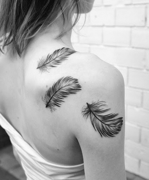 Cute black-and-white feathers tattoo on shoulder