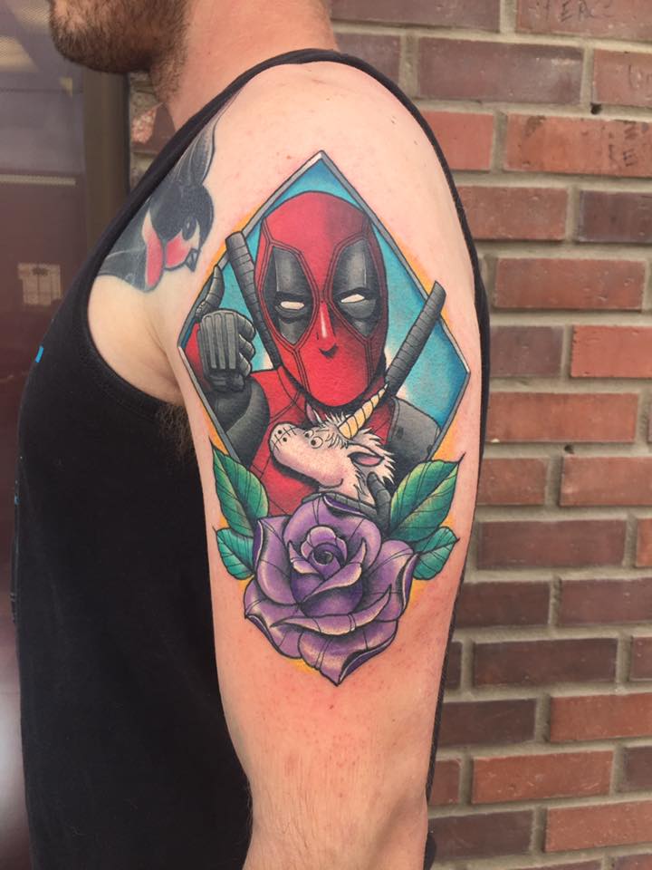 Cute deadpool with unicorn toy tattoo on shoulder