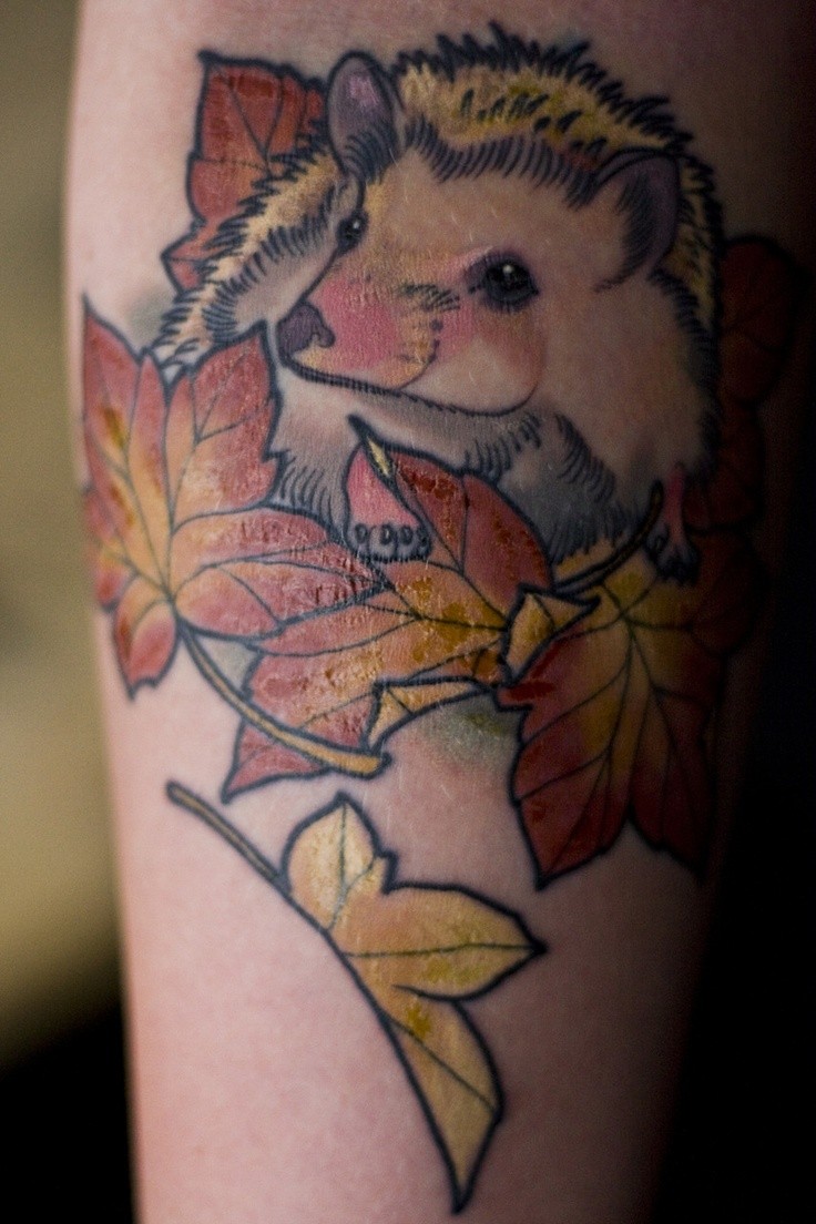 Cute girly hedgehog with autumn leaves tattoo on arm