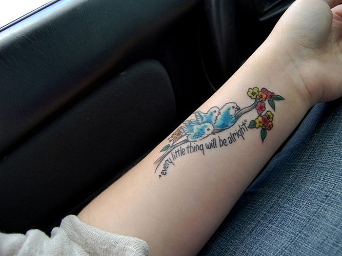 carina scrittura  con uccelli blu e piccoli fiori tatuaggio su braccio