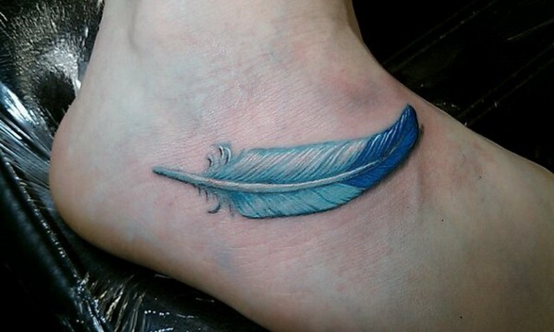 Tatuaje en el pie, pluma hermosa de color azul claro