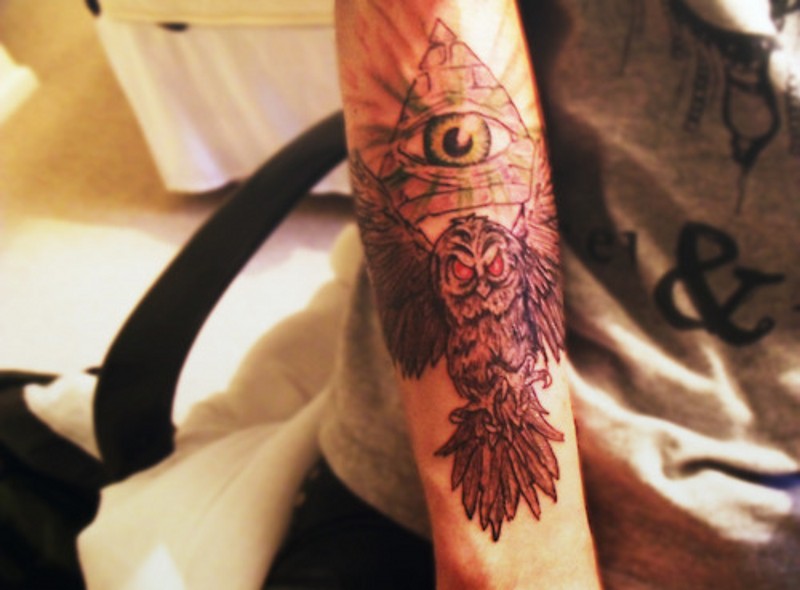 Demonic like colored evil animal owl with Masonic pyramid tattoo on arm