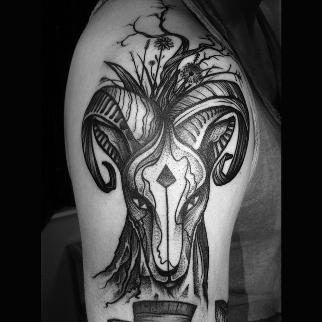 Devilish black-and-white ram head tattoo for men on upper arm