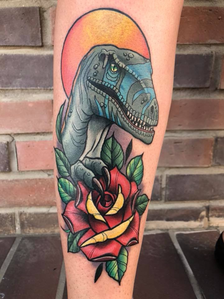 Dinosaur and rose tattoo on leg