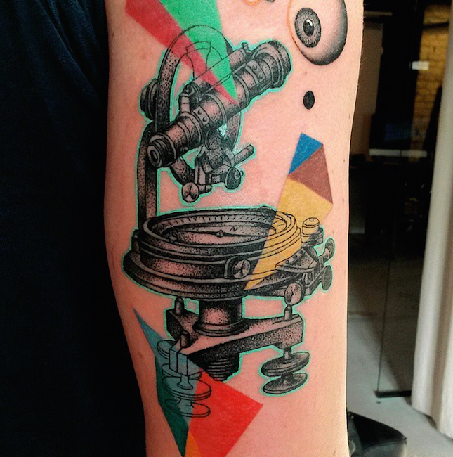 Dotwork style colored upper arm tattoo of telescope
