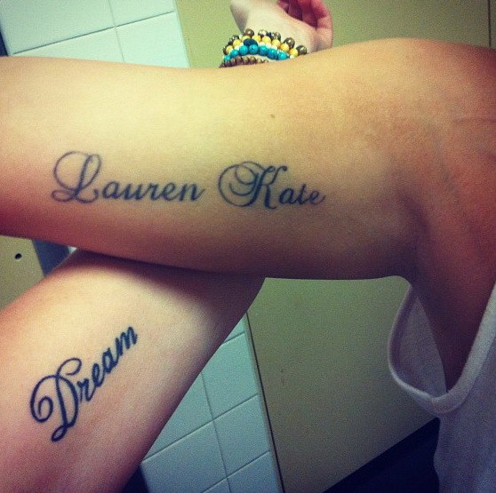 Tattoos mit Aufschriften &quotTraum" und " Lauren Kate" auf Armen