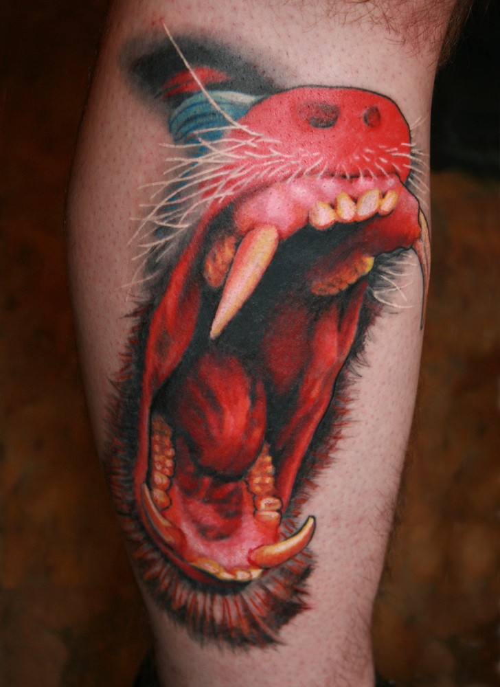 Tatuaje  de rostro de babuino furioso  en la pierna