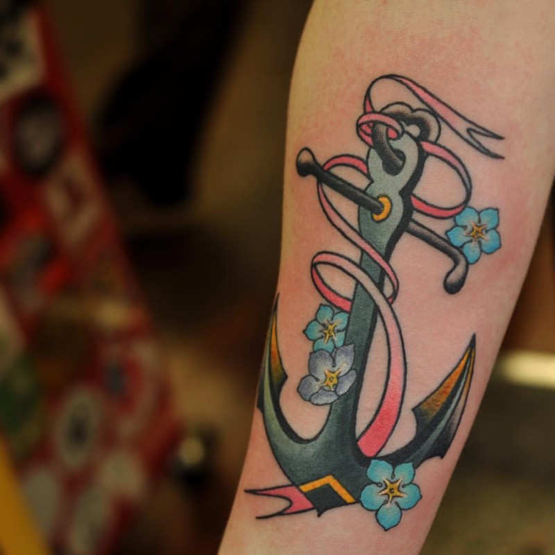 Fairy old school anchor with blue flowers and red ribbon tattoo on forearm
