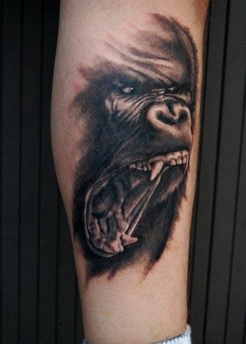 Fearful black-ink gnarling gorilla tattoo on leg