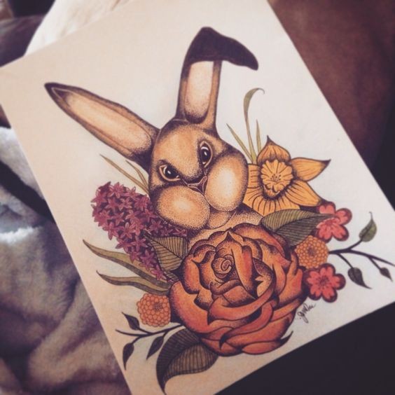 Fine brown rabbit looking out of flowered bush tattoo design