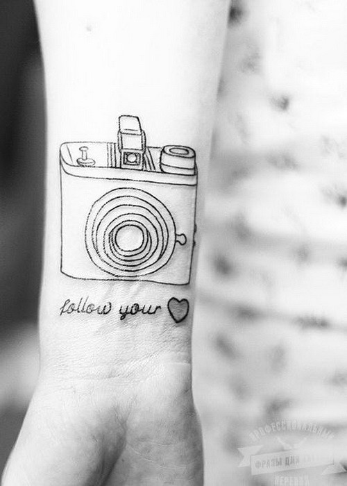 Follow your heart quote with a camera tattoo on arm
