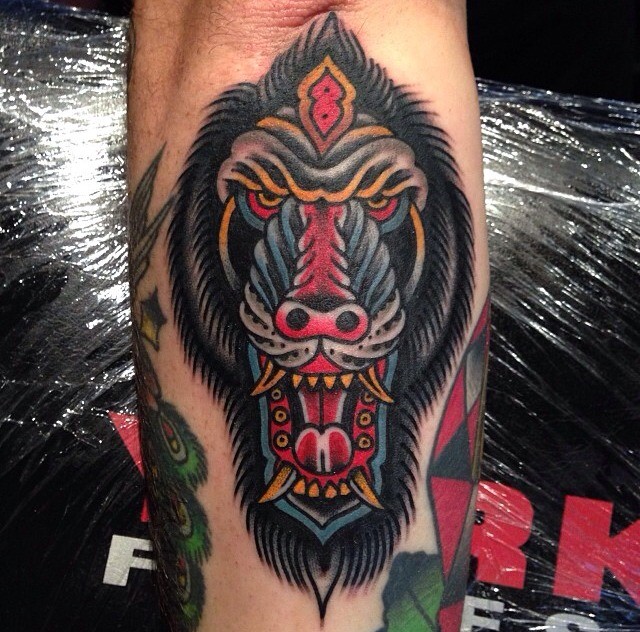 Frightened colorful baboon head tattoo on arm