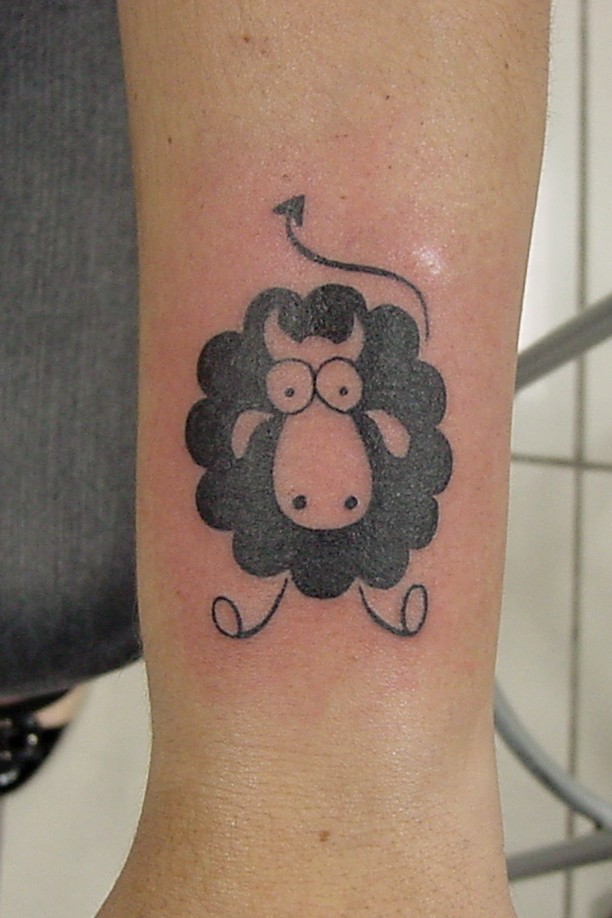 Funny black-and-white sheep tattoo on arm