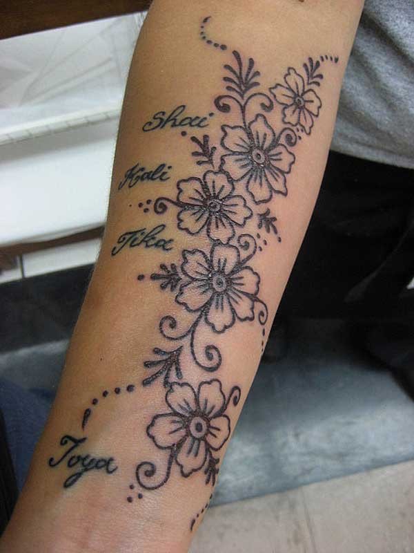 Girly black-and-white flower tattoo with name quotes on forearm