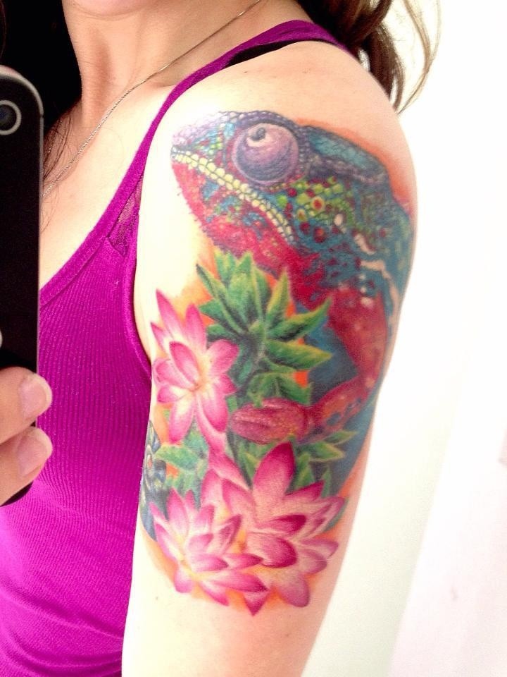 Girly vivid colored chameleon with pink flowers tattoo on arm
