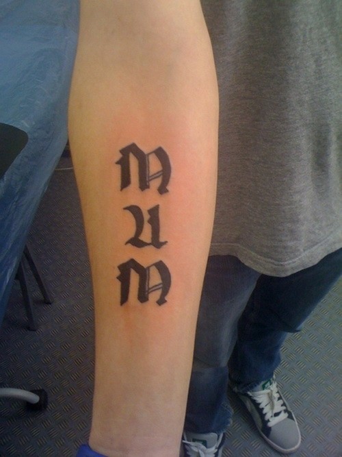 Gothic-lettered mum word tattoo on forearm