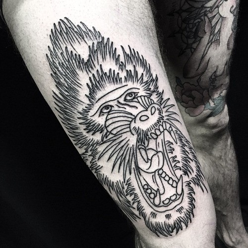 Great black-and-white baboon head tattoo on thigh