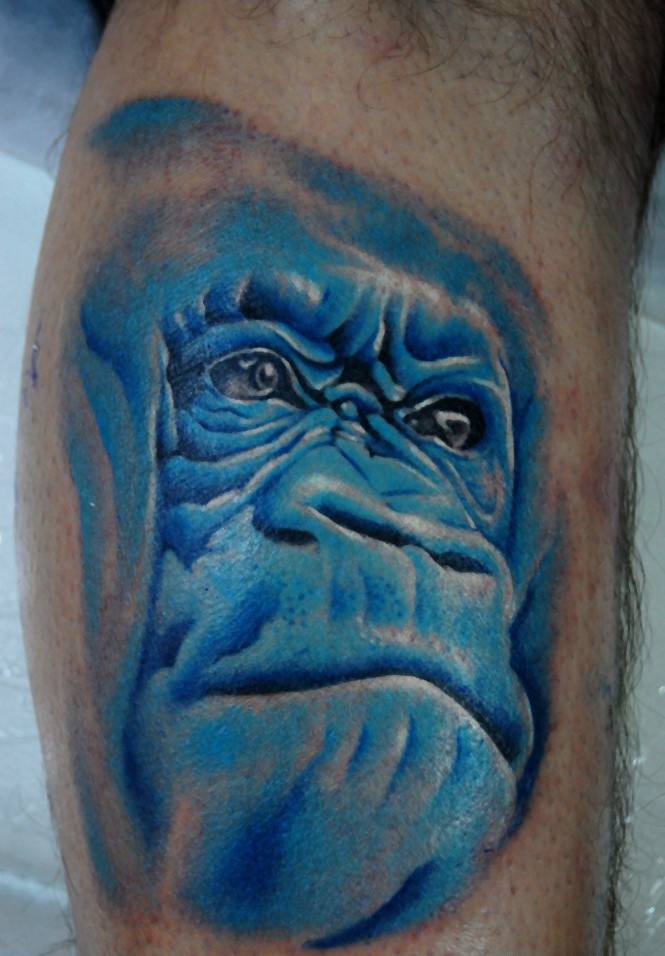 Tatuaje en el brazo,
cara de chimpancé azul