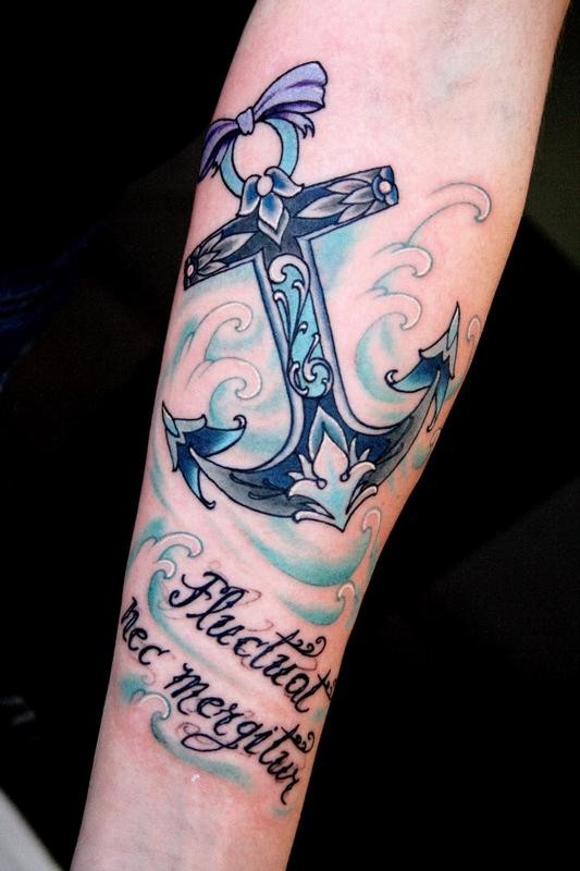 grande ancoraggio blu riccioli con fiocco e scritto tatuaggio su braccio