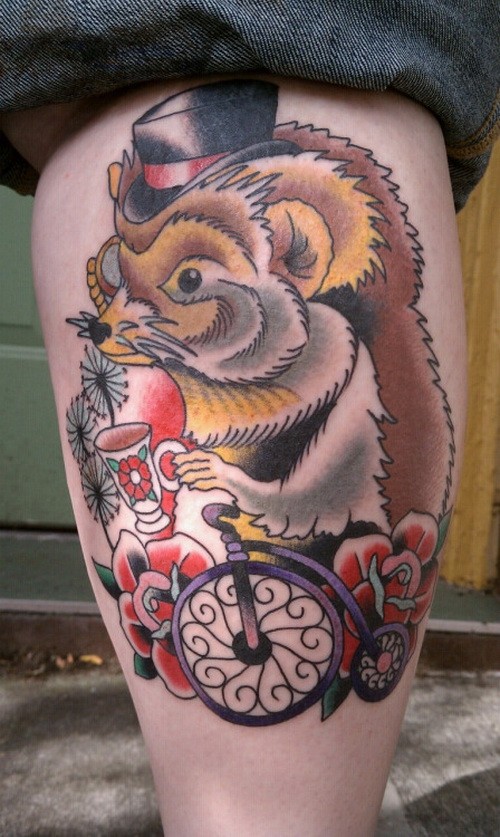 Great old school colorful hedgehog in hat on bicycle tattoo on shin