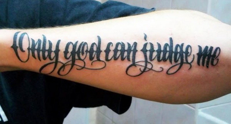 Tatuaje en el antebrazo, 
 inscripción sólo Dios puede juzgarme, letra cursiva elegante