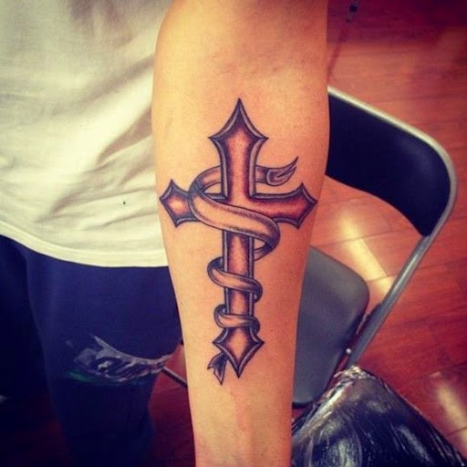Tatuaje de cruz con cinta en el antebrazo