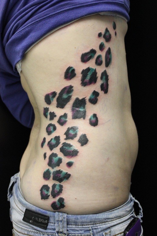 Gren and violet cheetah print tattoo on side