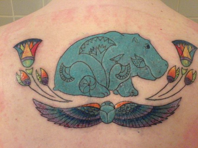Tatuaje en la espalda,
hipopótamo y flores y alas